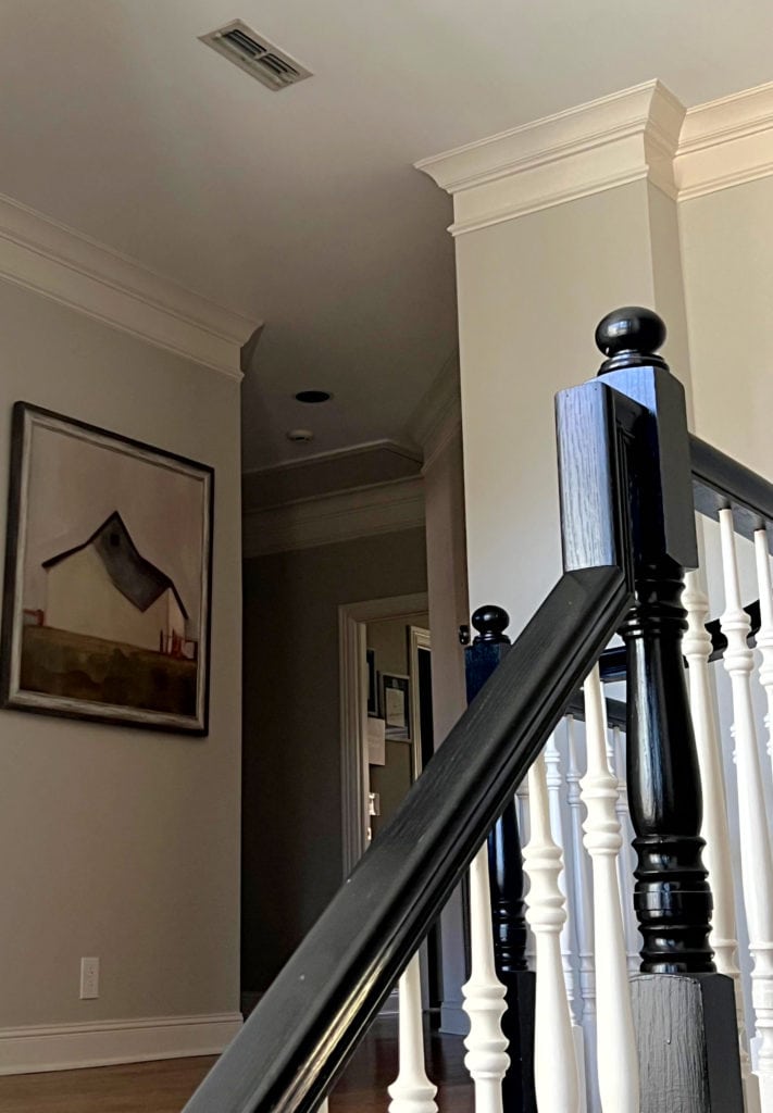 Staircase wood hand railing painted Sherwin Williams Tricorn Black with white spindles