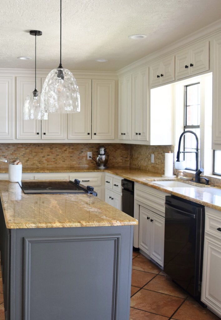 Black appliances, Benjamin Moore Ashwood Moss gray green painted island, painted cabinets, Moderate White, Sherwin. Travertine, granite countertops, orange tile floor. Kylie M interiors Edesign
