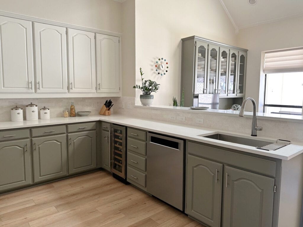 Kitchen with peninsula, 2 color palette, White Dove uppers, Benjamin Antique Pewter lowers, stainless steel apppliances, white quartz, Maritime White beige on wall. Kylie m Ede