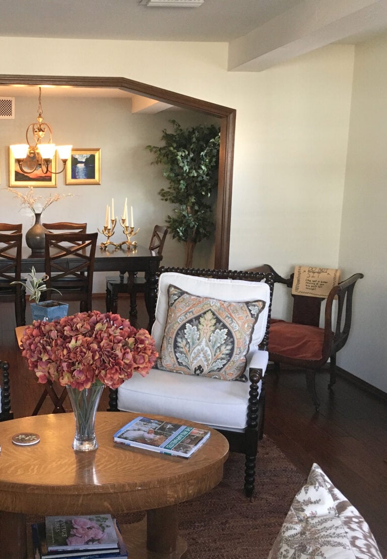 Benjamin Moore Antique White, off-white cream paint color, dark wood trim, dark floor and furniture, arched opening to dining room. Kylie M client photo