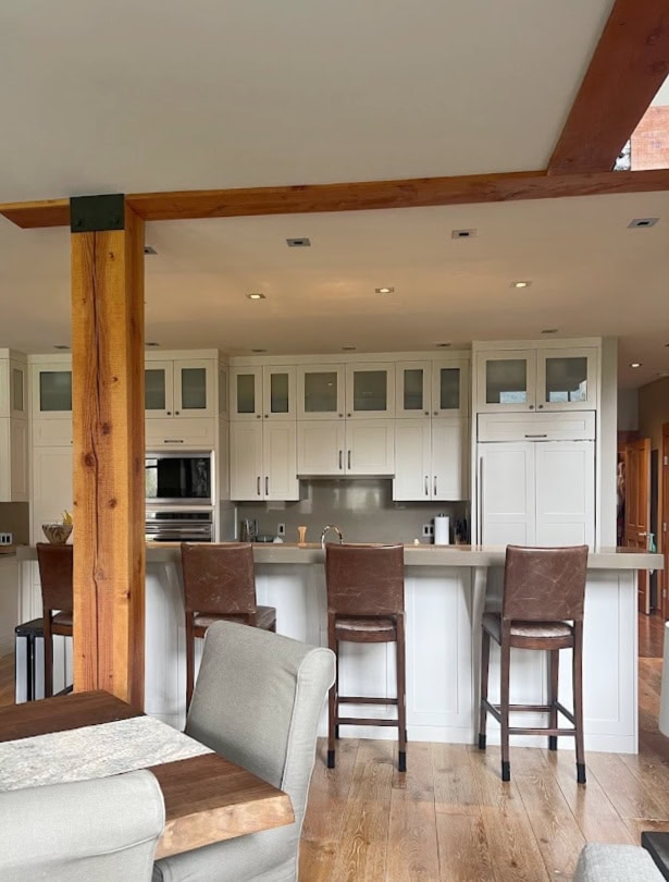 Benjamin Moore Natural Cream painted kitchen cabinets, taupe greige. Brown quartz countertop, oak floor.