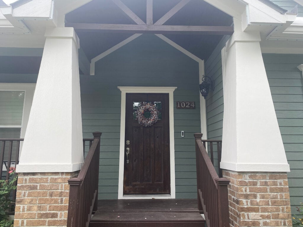 Exterior best green paint shade of paint, Sherwin Williams Retreat Shoji White trim, beige brick and warm asphalt roof. Kylie M client photo
