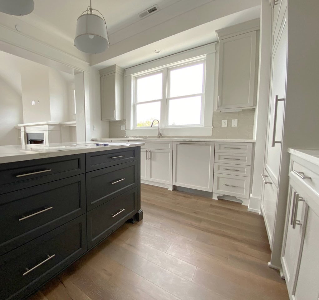 Iron Ore painted kitchen cabinets and island, cabinets Sherwin Agreeable Gray, a greige, walls are Snowbound. Wood floor. Kylie M client photo