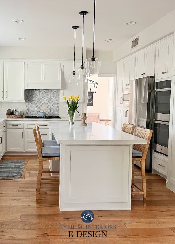 Cabinets painted Sherwin Williams Pure White, walls Benjamin Moore warm gray Classic Gray, Vadar White Aura quartz, wood floor, Serena Lily rattan stools, blue accents. subway tile