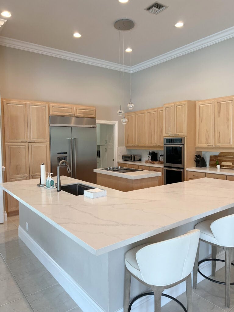 Light maple wood kitchen cabinets, Calacatta Misty white quartz countertop, Sherwin Williams Modern Gray paint color on walls