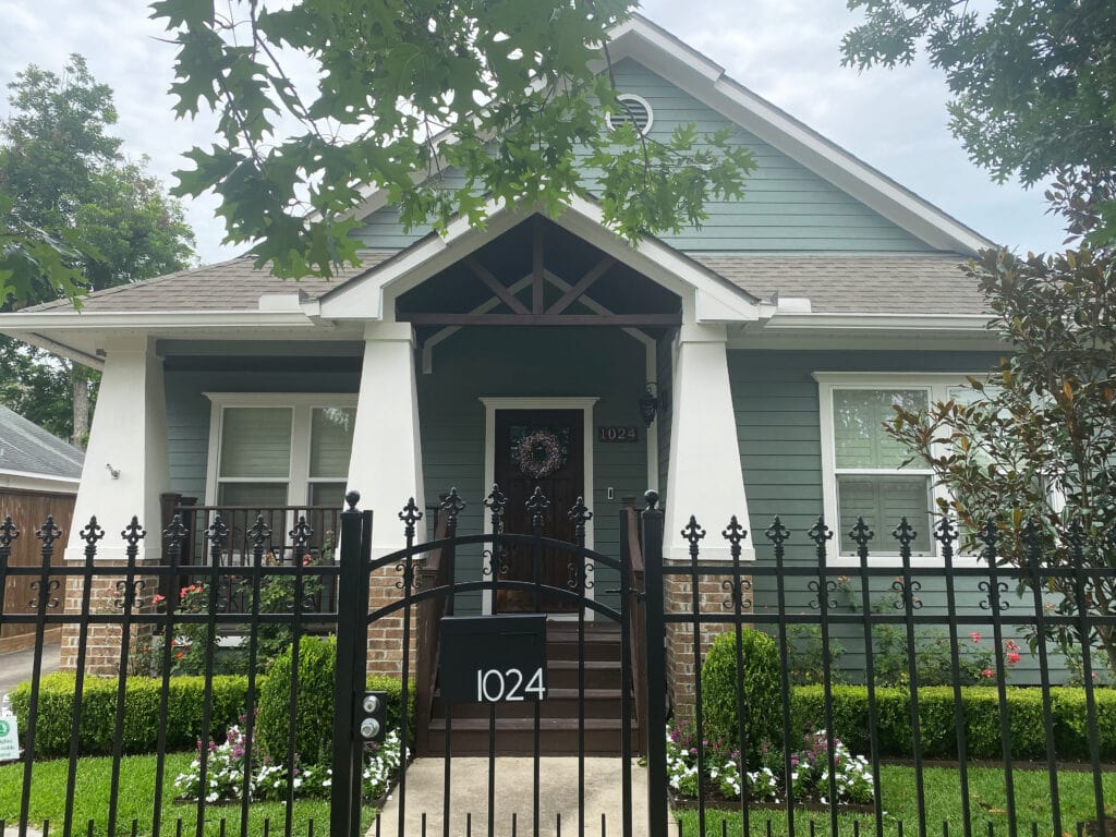 Sherwin Williams green painted exterior, Retreat siding, beige brick, Shoji White trim, dark stained wood accents. Kylie M client photo.