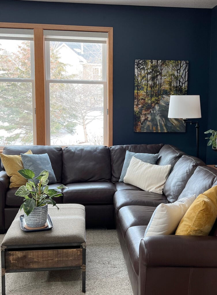 Benjamin Moore Hale Navy with orange stain on wood trim, and leather sectional. Beige carpet, great accent wall color. Kylie M ONline paint color consulting