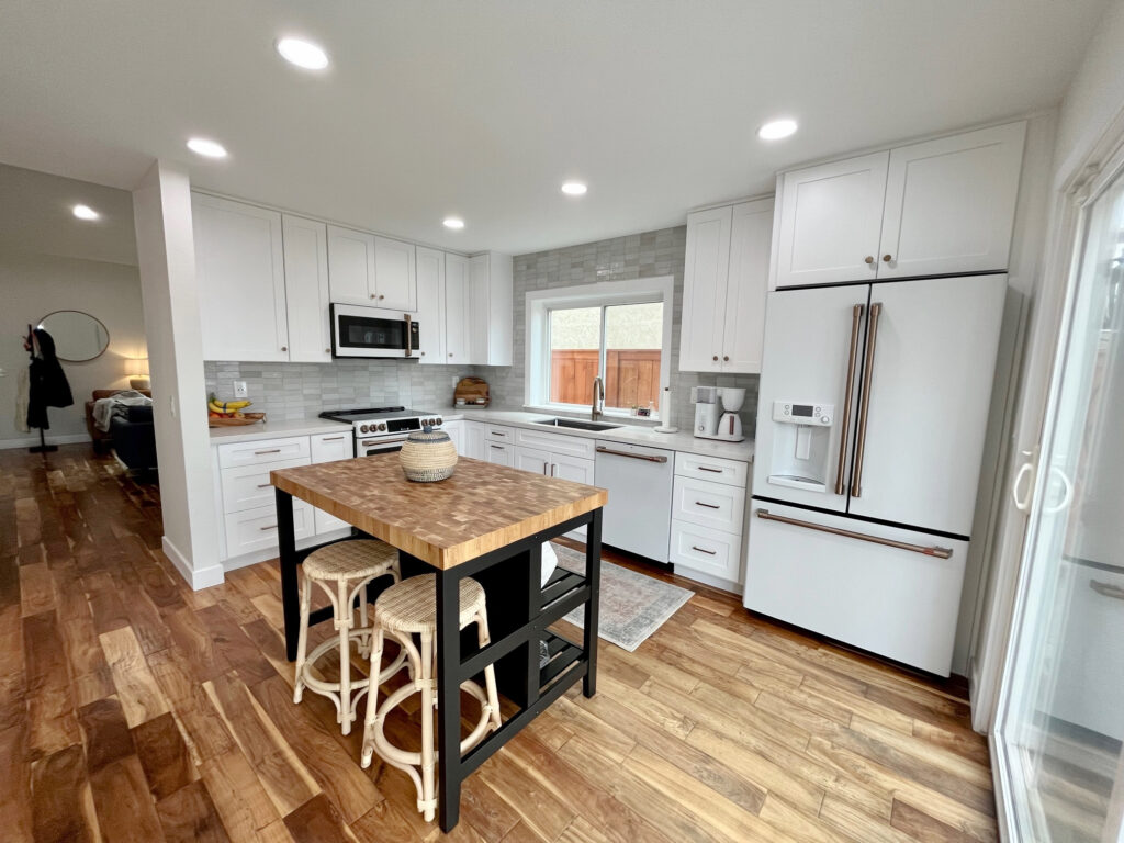 Kitchen appliances, fridge, IKEA ISLAND, BUTCHERBLOCK AND BLACK, KYLIE M.GE Cafe white, champagne brass, CLE ZELLIGE WEATHERED WHITE TILE AROUND WINDOW, MIS CALACATTA IZARO WHITE QUARTZ COUNTERTOP