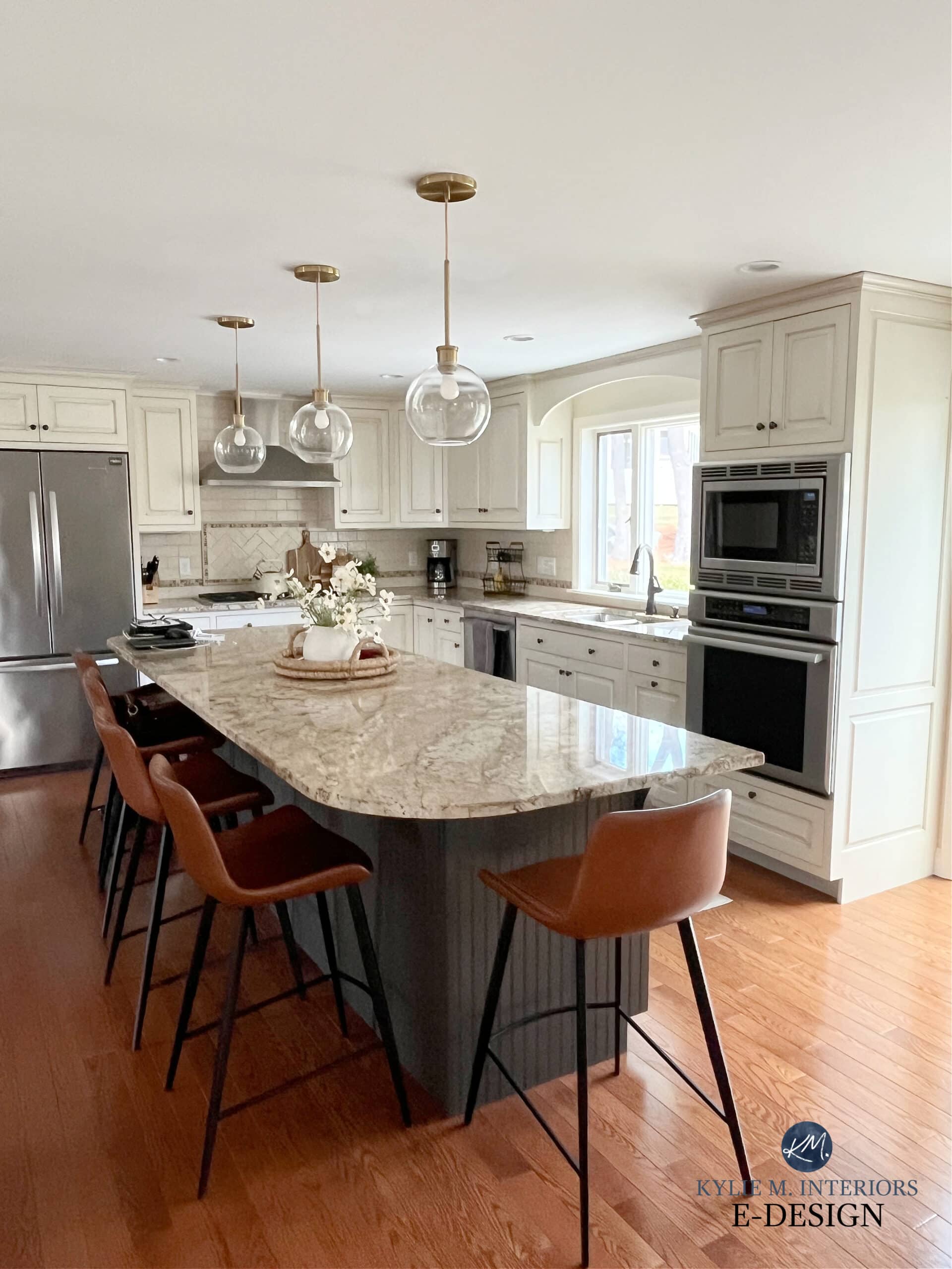 Kitchen island painted Sherwin Williams greige, Urbane Bronze, red oak stain wood floor, cream, glazed kitchen cabinets, cream subway tile backsplash, gold pendant lights, Kylie M Edesign