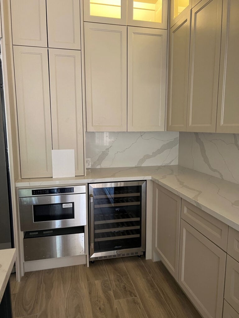MSI Calacatta Idillio white quartz marble look countertop, Sherwin Williams Sandbar painted cabinets quartz backsplash.
