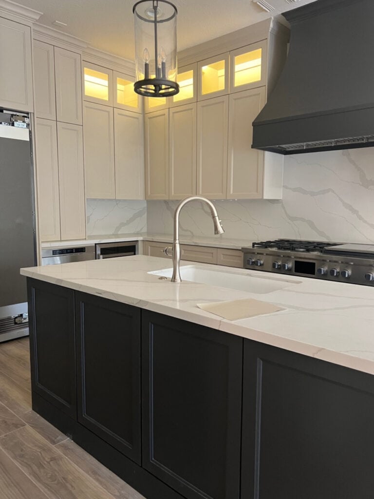 MSI Calcatta Idillio, Sherwin Williams Iron Ore kitchen painted island and range hood, Sandbar beige tan cabinets. Quartz countertop on backsplash too,