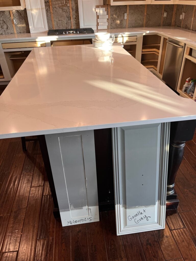 Samples of Benjamin Moore Metropolis and Sherwin Williams Gauntlet Gray on painted island with Calacatta Gold quartz countertop, Kylie M Interiors Edesign.