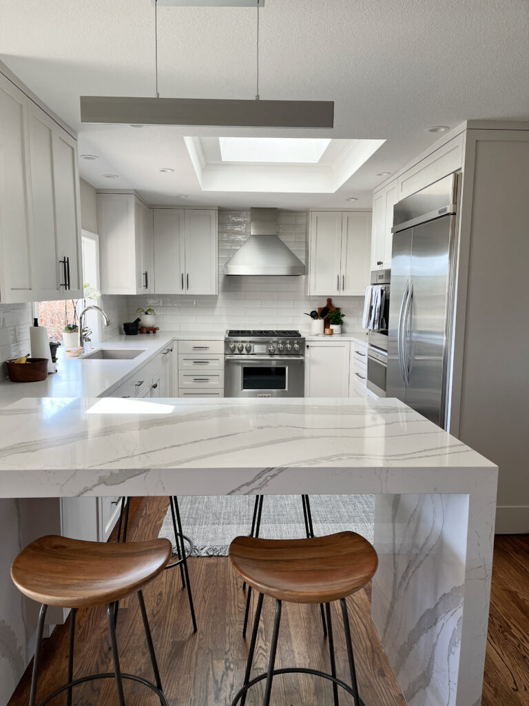 Sherwin Williams Eider White painted kitchen cabinets, off white gray, Cambria Brittanica and a light gray quartz.