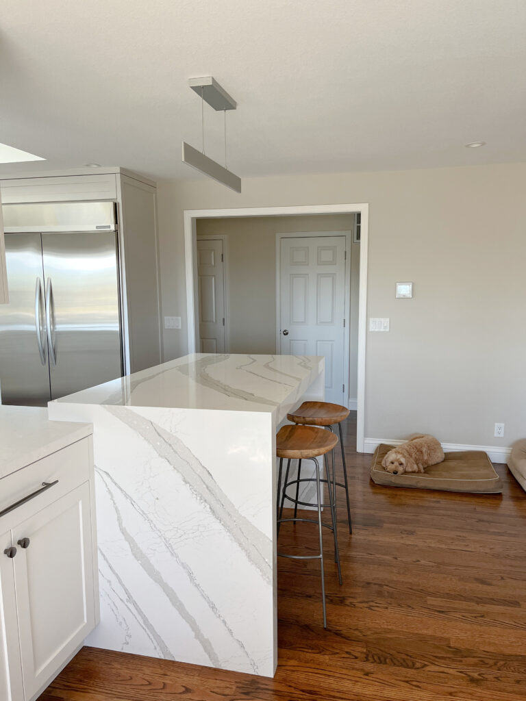 Sherwin Williams Modern Gray, greige taupe, red oak stained floor, Cambria Brittanica white quartz countertop, modern light.