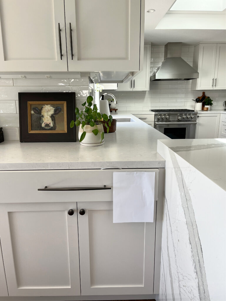 Sherwin Williams Off white painted kitchen cabinets - Eider White with light gray quartz countertop