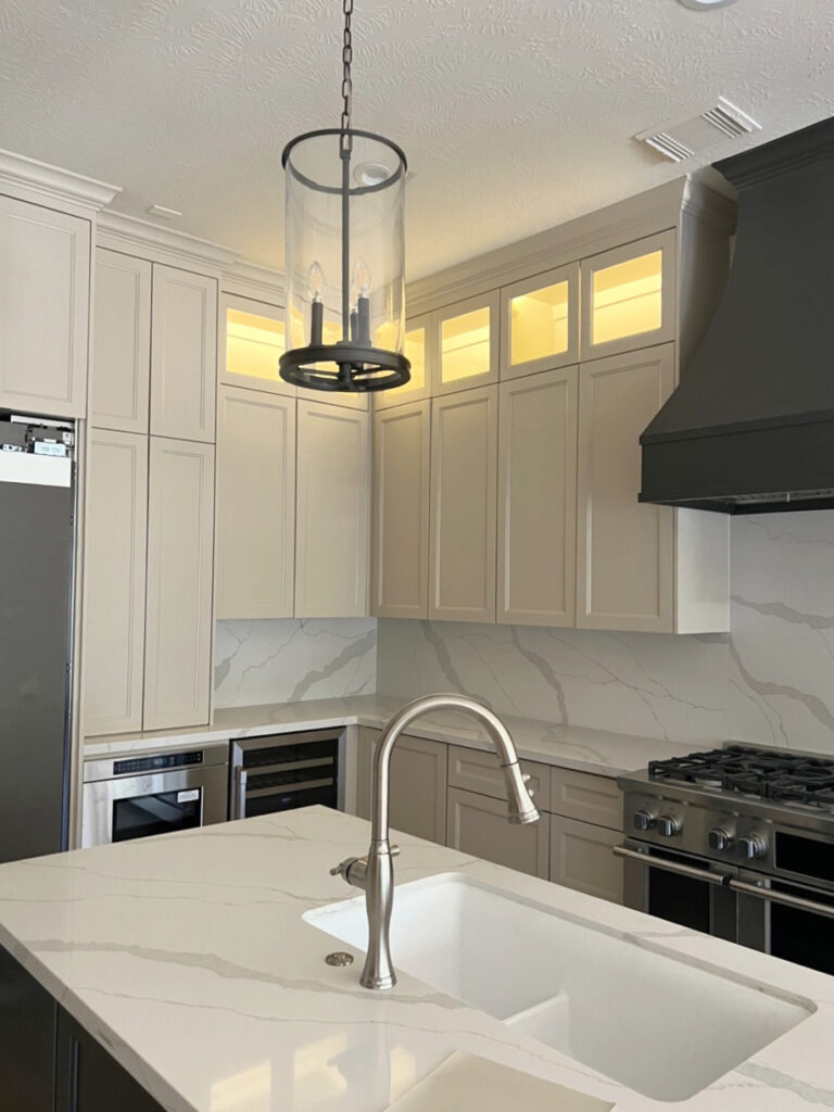 Sherwin Williams Sandbar MSI quartz Calacatta Idillio, Iron Ore soft black paitned range hood, pendant light