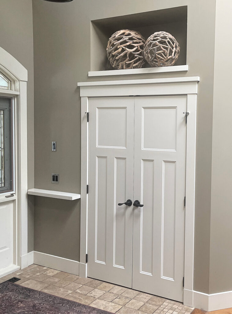 Warm cream trim and door painted Benjamin Moore Feather Down with C2 Sea Salt walls - green greige, travertine tile.