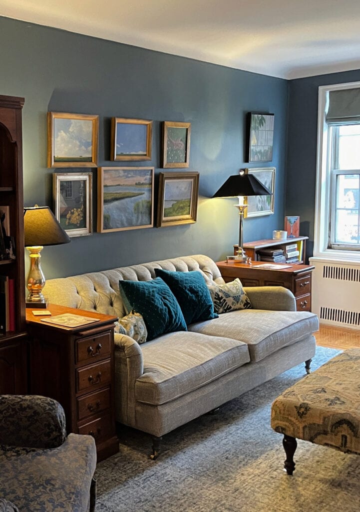 Benjamin Moore Blue Spruce in vintage style living room wiht art collection. Moody vibe