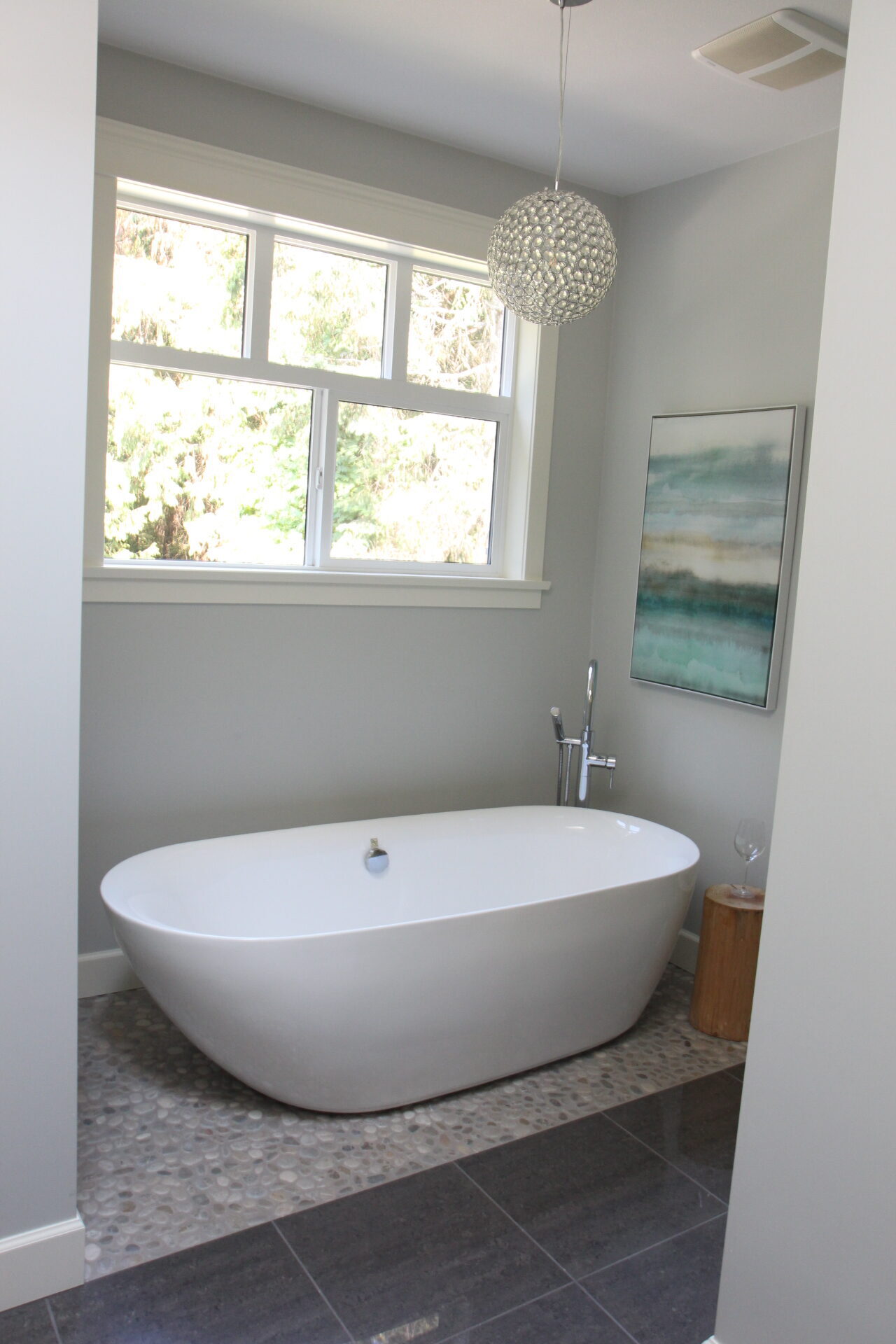 Benjamin Moore Wickham Gray, north facing bathroom, pebble rock floor, dark gray floor tile, freestanding tub, warm up a gray room