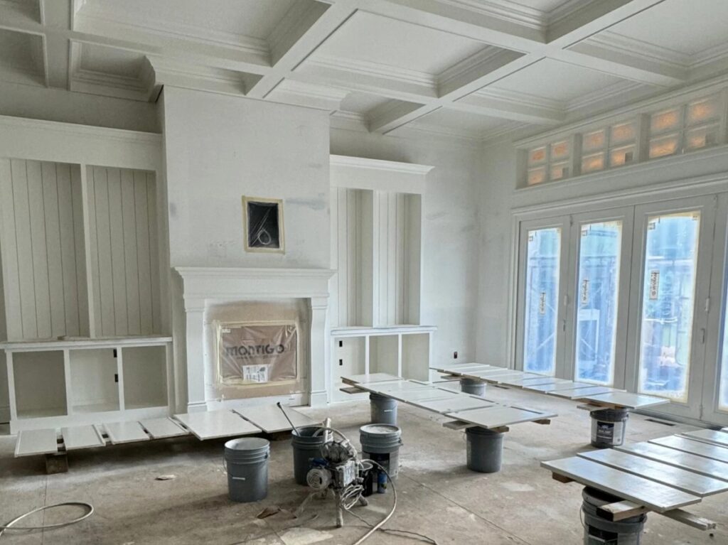 Sherwin Williams Alabaster in large open layout living room, built-ins, french doors to patio, fireplace surround, coffered ceiling, possible north or east facing light