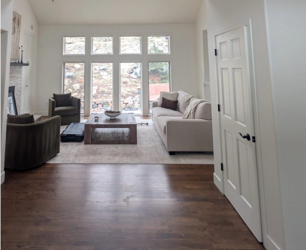 Sherwin Williams Alabaster in room with dark wood floor, pottery barn accent chairs, tall windows, warm creamy white in possible northern light