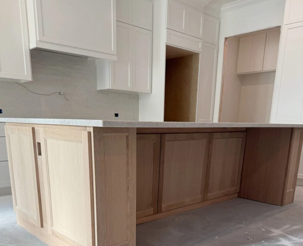 Sherwin Williams Alabaster warm white painted cabinets in natural light, Classic Gray and Weathered Oak stain, quartzite island like Taj Mahal