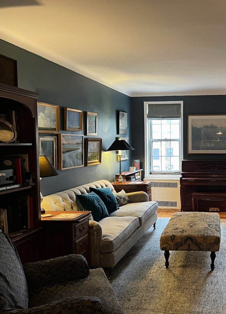 Vintage style livingroom with home decor, furnitures and artwork collection on Benjamin Moore Blue Spruce paint color walls, Simply White trim. Kylie M Color Expert