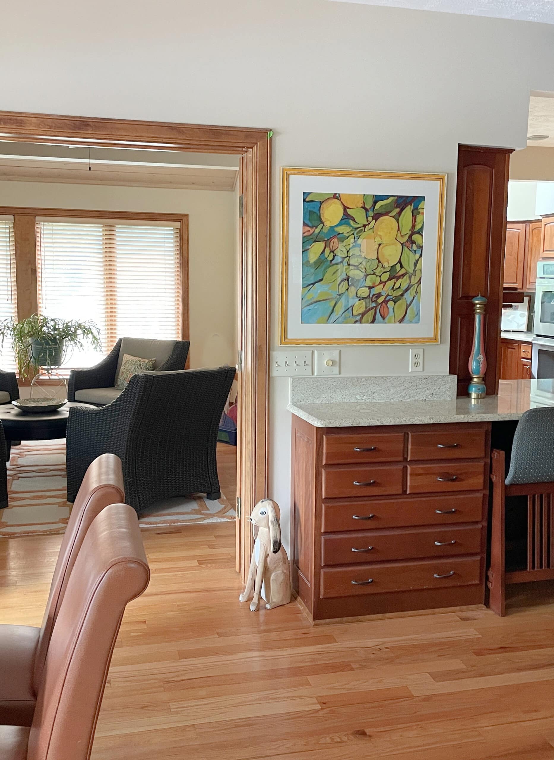 Benjamin Moore Muslin in kitchen and sitting room with red-stained wood cabinets and oak floor, wood trim