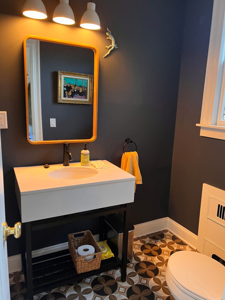 Benjamin Moore Cheating heart, dark blue black gray paint color in small bathroom or powder room with patterned tile floor