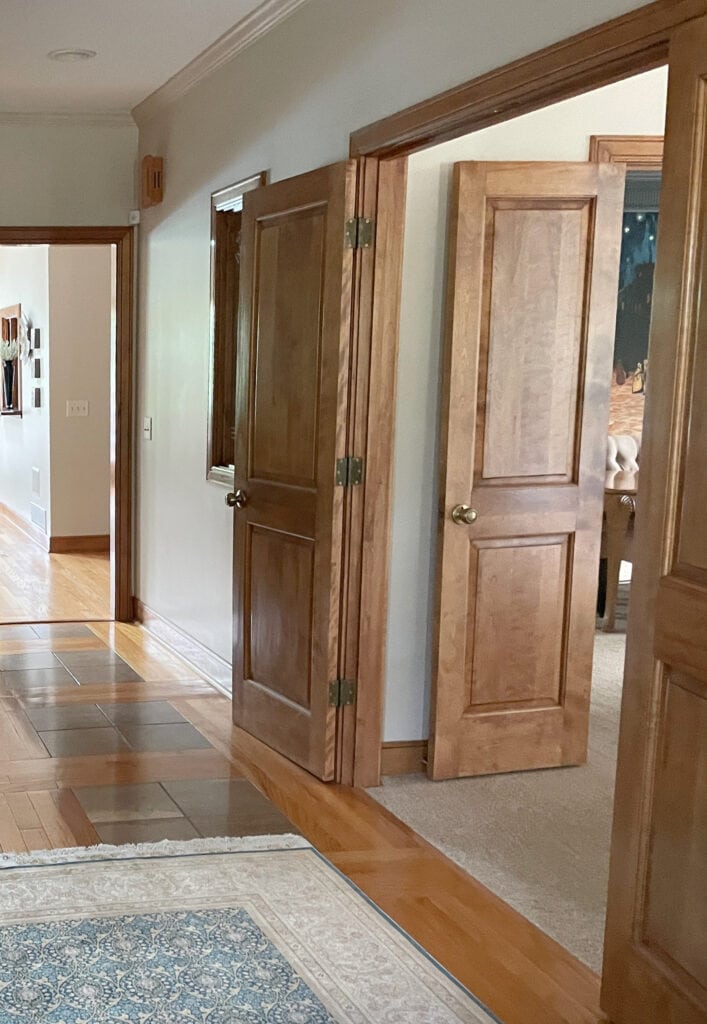 Benjamin Moore Muslin in entryway with beige taupe tile and wood floor. Wood trims in cherry.