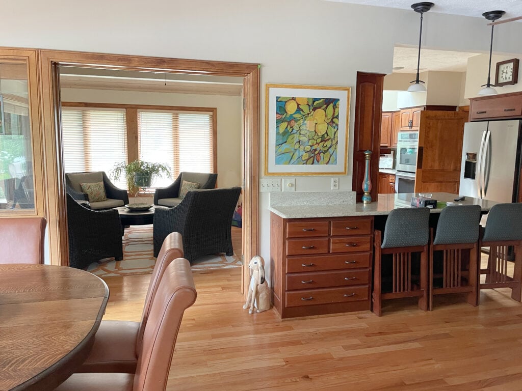 Cherry wood red stained kitchen cabientse, warm orange-red wood floor, maple look trim, Benjamin Moore Muslin beige paint color on walls,