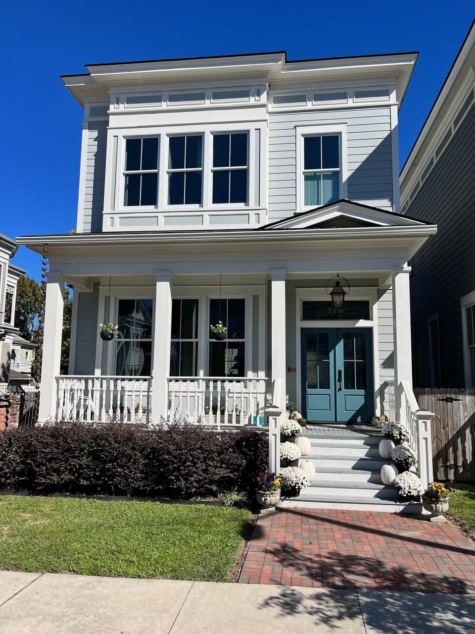 Front door painted medium blue, blue-green, Benjamin Moore Bella Blue, exterior gray siding, Half Moon Crest, front porch, white trim. Kylie M Edesign