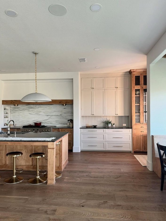 Sherwin Williams Aesthetic White kitchen walls, beige painted cabinets, wood floor, wood island, marble look backsplash and countertop