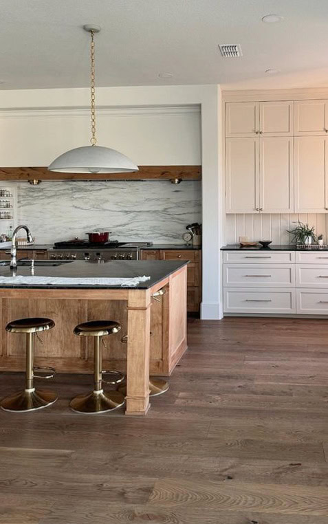 Sherwin Williams Aesthetic White paint color on walls, beige cabinetes, marble look backsplash, wood floor and wood stained island, large range hood