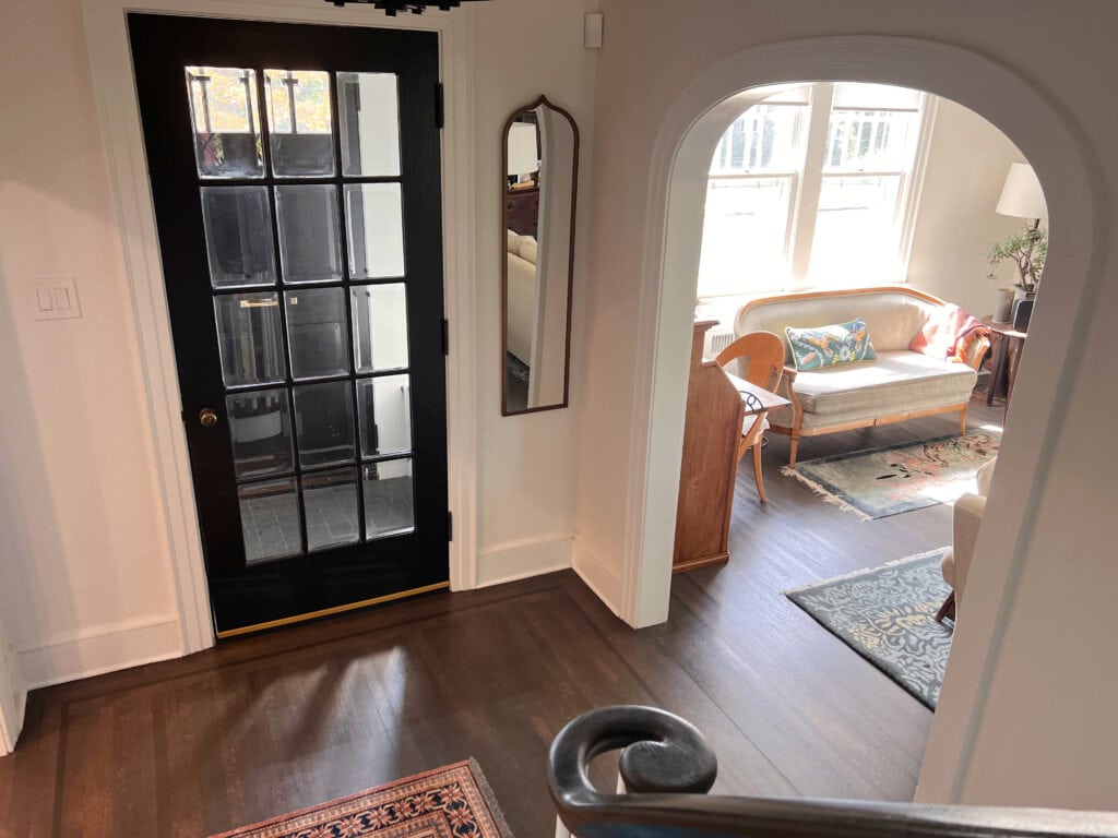 Sherwin Williams Alabaster, Extra White, black glass door, arched doorway opening, dark wood floor. Entryway. Kylie M Online color expert, client photo