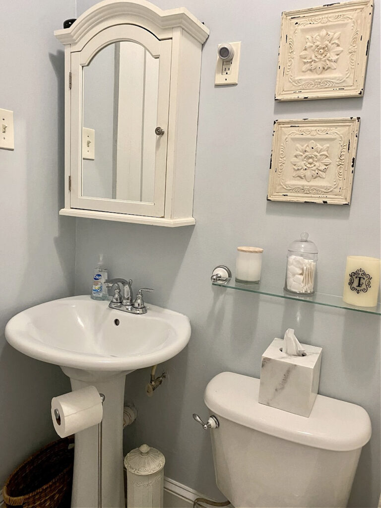 Sherwin Williams Hinting Blue in small bathroom, white pedestal sink, cream acceints. Best blue paint color