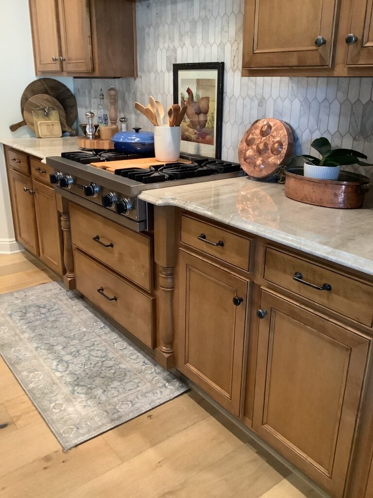Wood cabinets, Taj Mahal quartzite, old world feel, zellige tile backsplash, wood floor. Kylie M