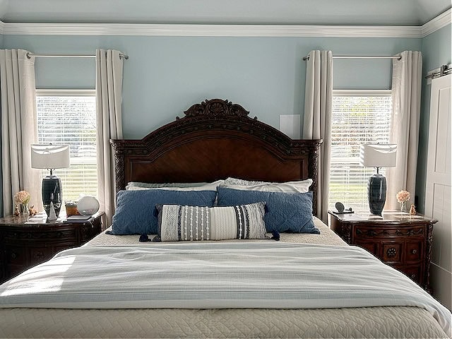 best light blue paint color, Sherwin Williams Rain in bedroom with dark cherry red wood furniture, beige and blue bed linens, vaulted ceiling