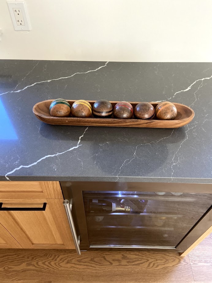 old croquet balls on dark charcoal quartz countertop with white vein, looks like marble, bar fridge, white oak. Kylie M Interiors. Home decor.