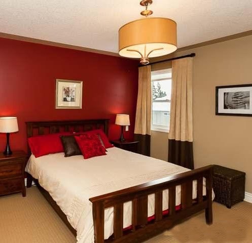 Bedroom with red feature wall before being painted.
