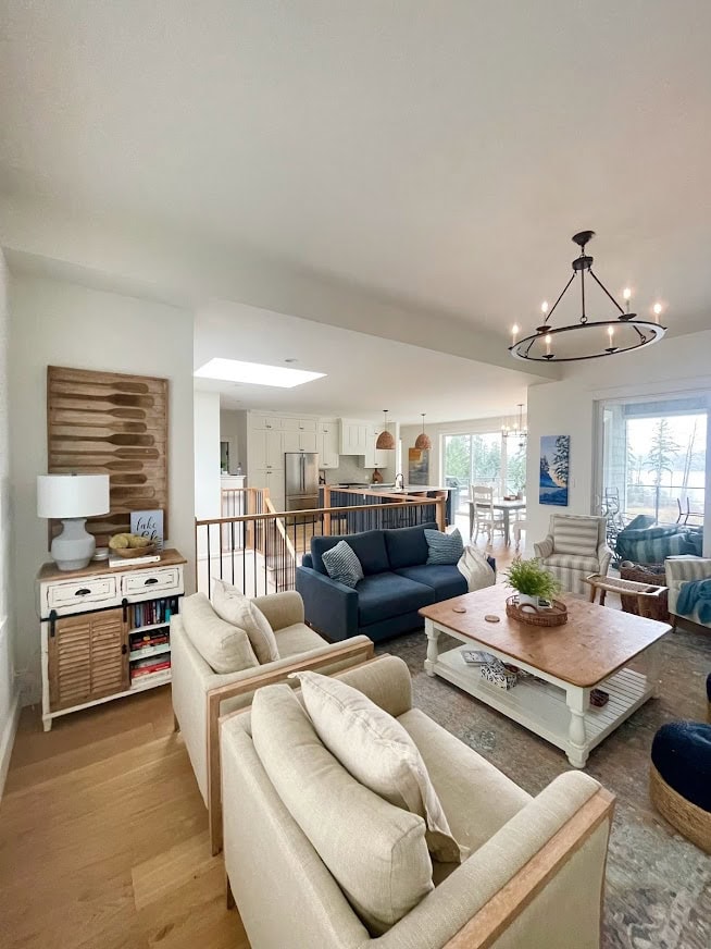 Open concept living room, kitchen, dining room, raised 10 foot ceiling, oak wood floor and open railing, blue accents. BEnjamin Moore White Dove walls, cabinets, trims, Kylie M Interiors