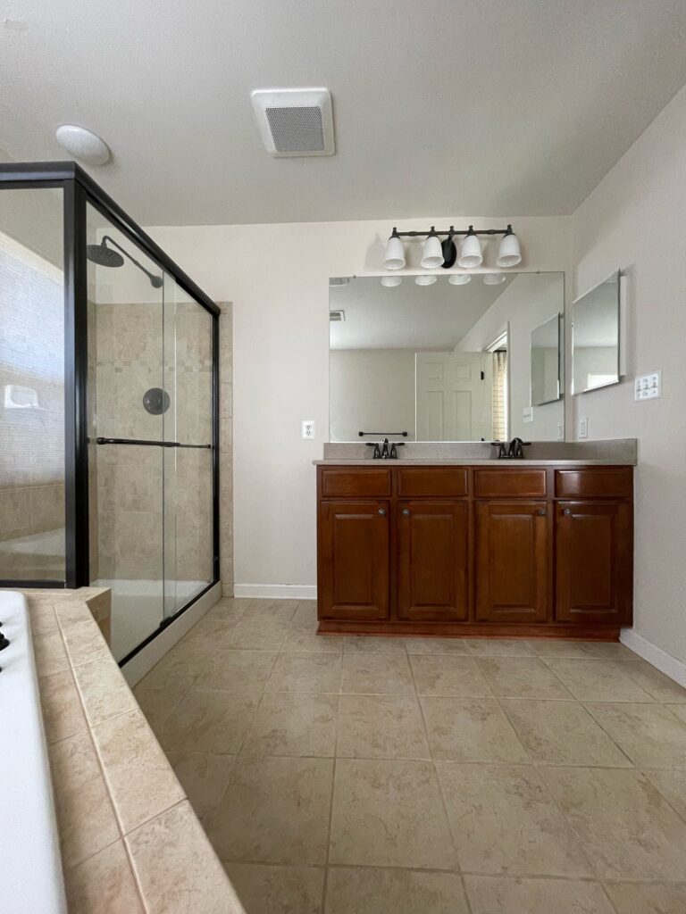 2000 bathroom with soaker tub, beige tile, wood maple vanity, corian countertop, black fixtures (2)