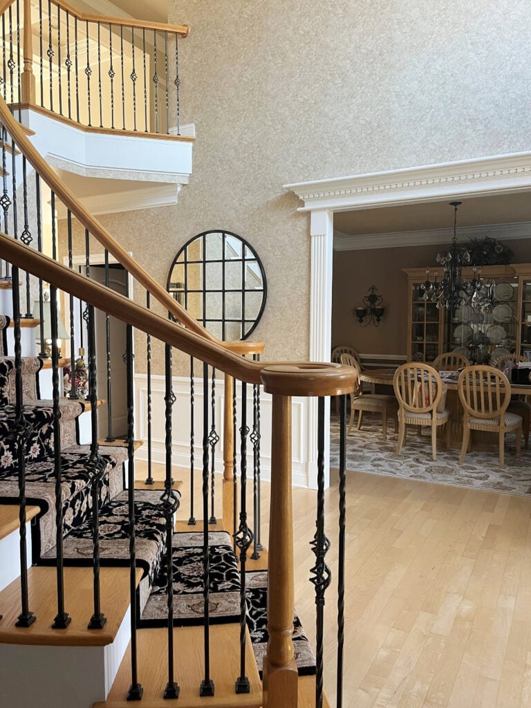 2000 staircase with oak wood hand railing and treads, maple floor, white trim, beige sponge paint look wallpaper, curved railing and staircase