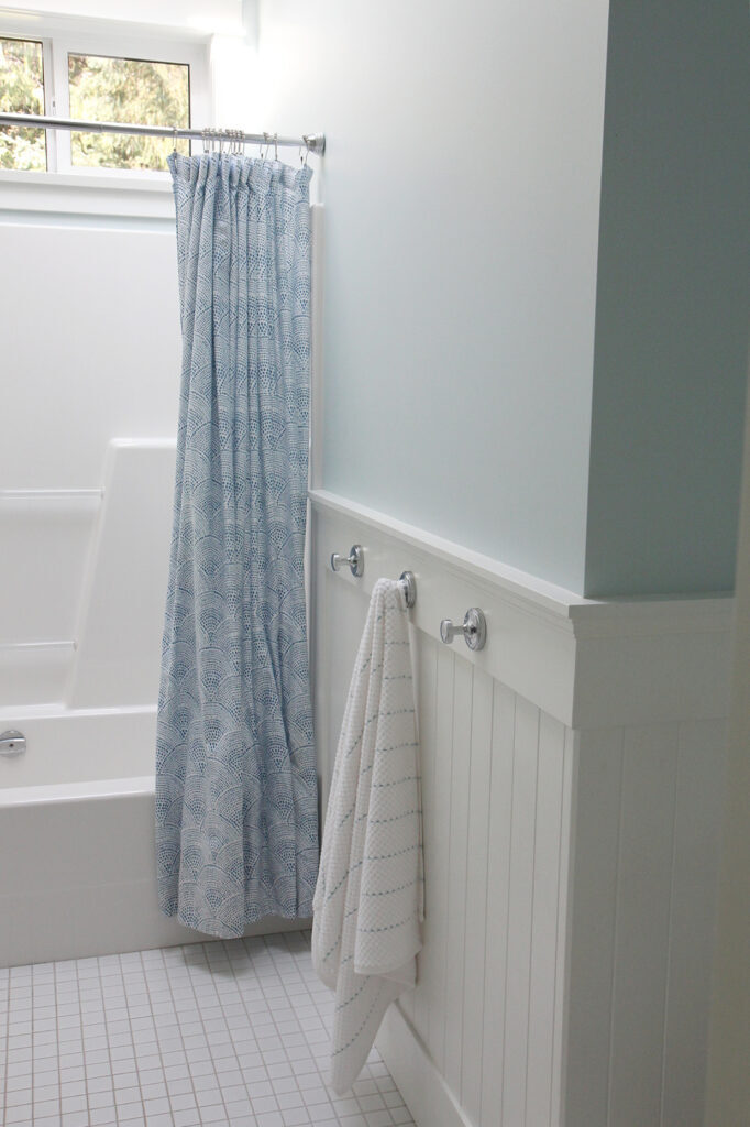 Benjamin Moore Ocean Air with warm white beadboard, small white tile floor, fibreglass acrylic shower surround, pretty blue paint color
