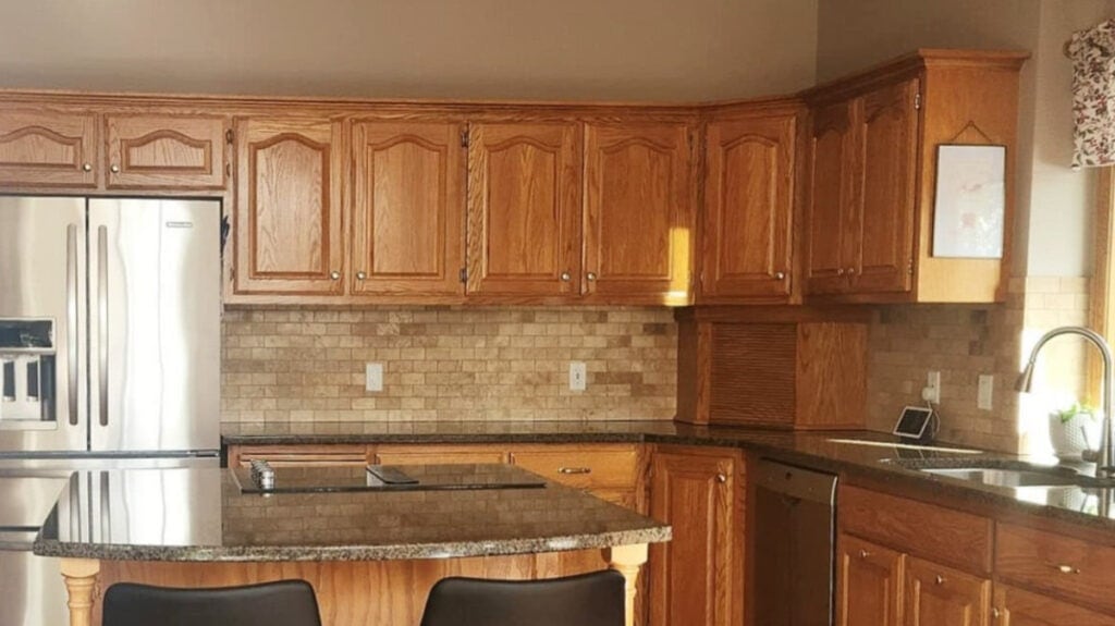 Kitchen with golden oak cabinets, update ideas for the travertine tile backsplash and granite countertops, oak flooring, 1990s