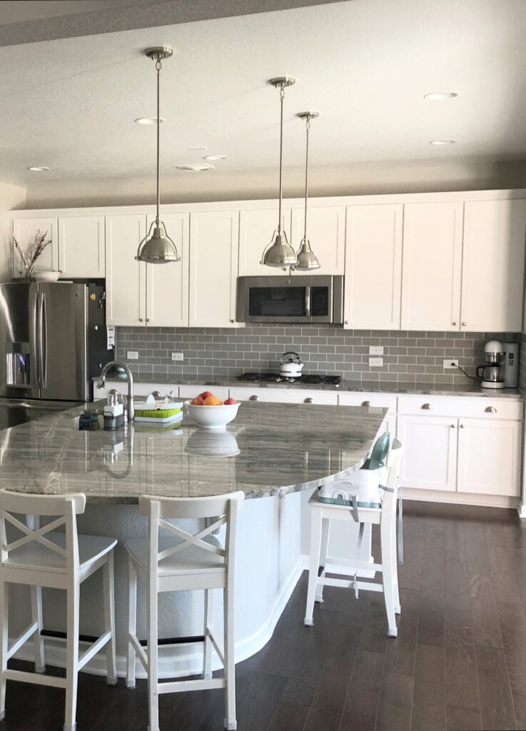 Repose Gray paint color on walls, white cabinets, dark gray-green subway tile backsplash, Fantasy Brown quartzite countertop, dark wood floor, curved island (1)