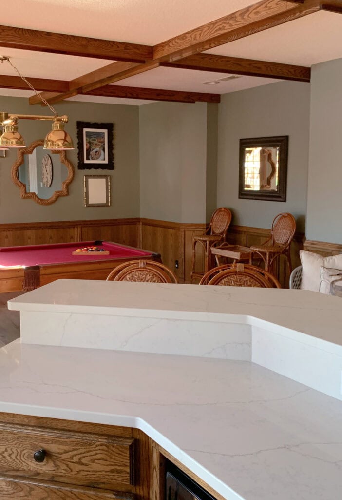 Sherwin Williams Evergreen Fog in red felt pool table reflecting pink , family room, new white quartz countertop, oak cabinets, wood panelling, wainscoting with wood beams and trim.