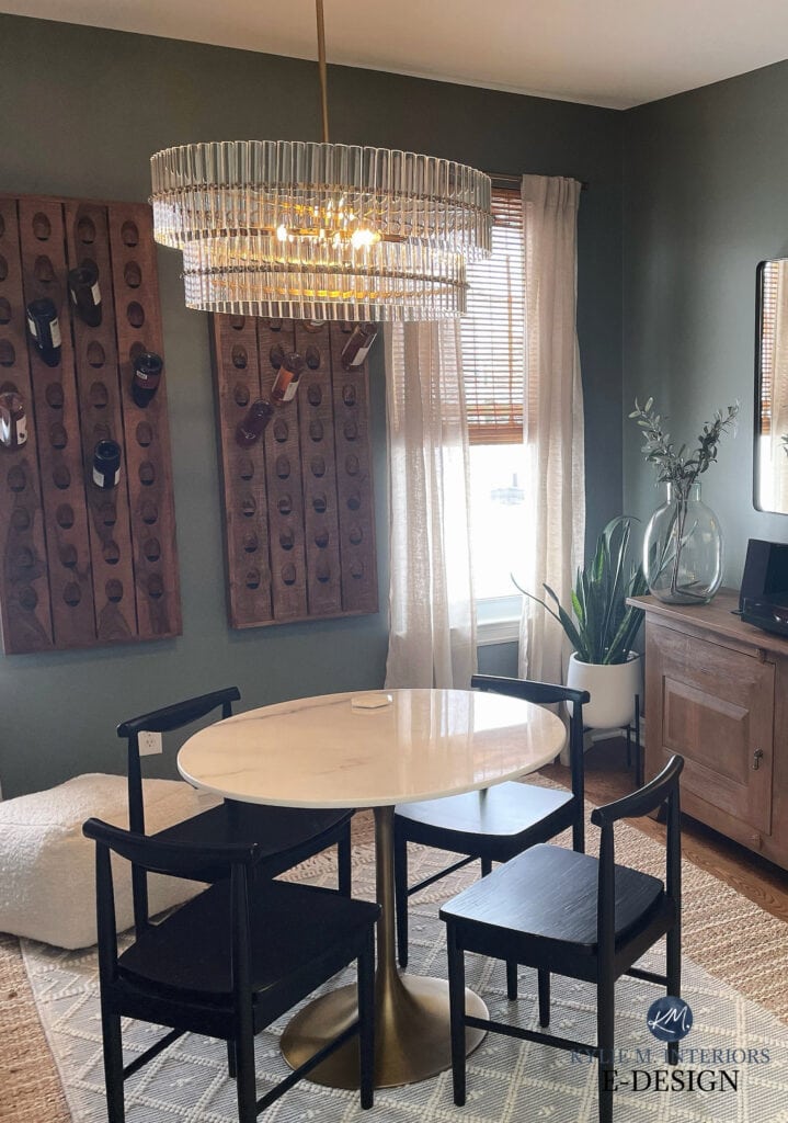 Small dining room area with marble round table, wall mount wine hold, Sherwin Williams Retreat best medium dark shade of green paint color, wood cabinet, crystal glass light fixture,