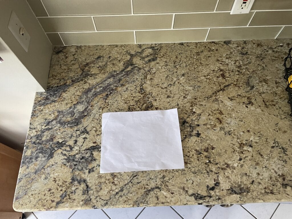 beige gold subway tile that coordinates with a 90s, 2000s style tuscan style kitchen granite countertop.