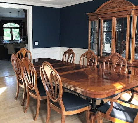 dark navy blue paint color on walls, Benjamin Moore Hale Navy, light wood floor, cherry red traditional formal dining room furniture, tray ceiling, white wainscoting